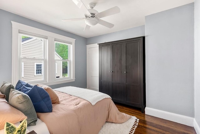 bedroom with baseboards, ceiling fan, and dark wood-style floors