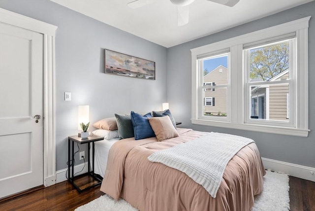 bedroom featuring a ceiling fan, baseboards, and dark wood-style floors