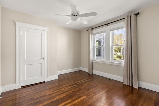 empty room with visible vents, baseboards, ceiling fan, and wood finished floors