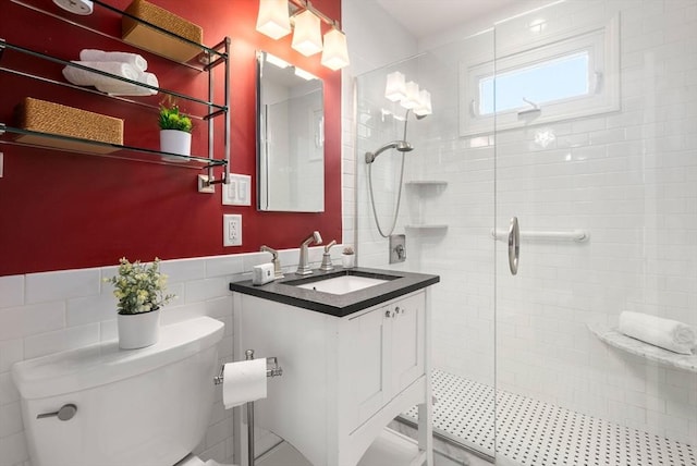 bathroom with vanity, tile walls, toilet, and a shower stall