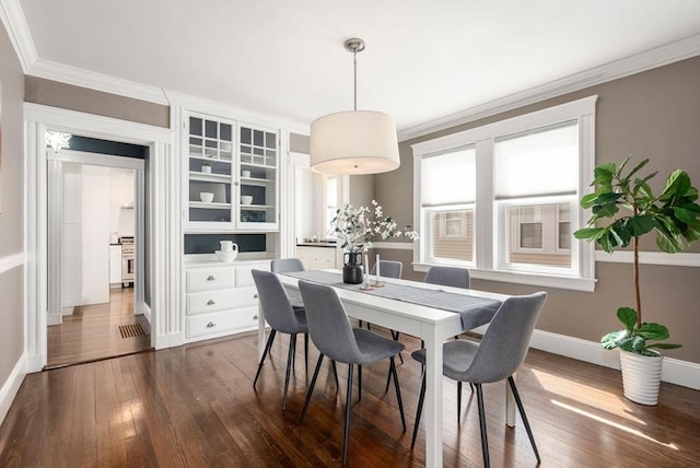 dining area with crown molding, baseboards, and dark wood-style floors