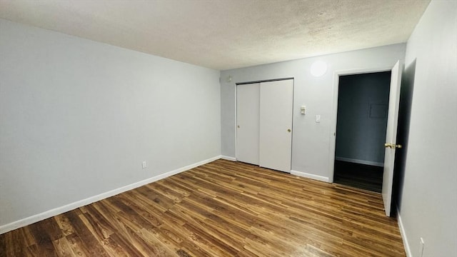 137 Winthrop St Unit 14A, Framingham, MA 01702 - unfurnished bedroom featuring wood finished floors, a closet, baseboards, and a textured ceiling