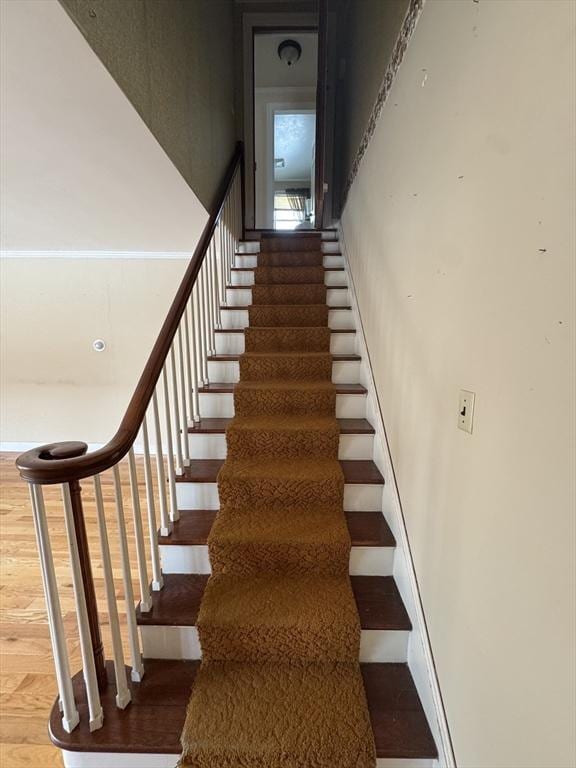 stairs with baseboards and wood finished floors