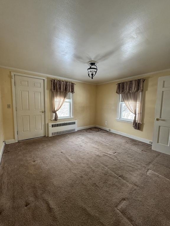 spare room with carpet floors, radiator heating unit, and baseboards