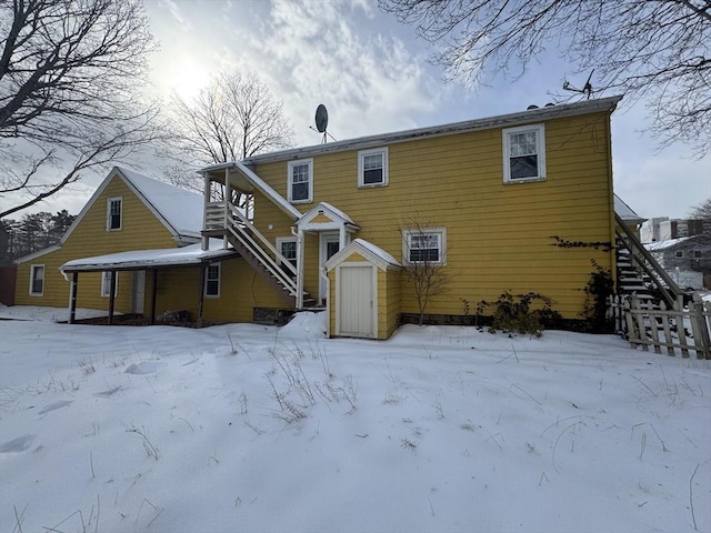 snow covered house featuring a garage