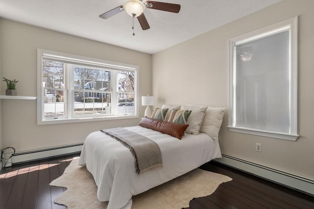 bedroom with a baseboard heating unit, dark wood finished floors, and a ceiling fan