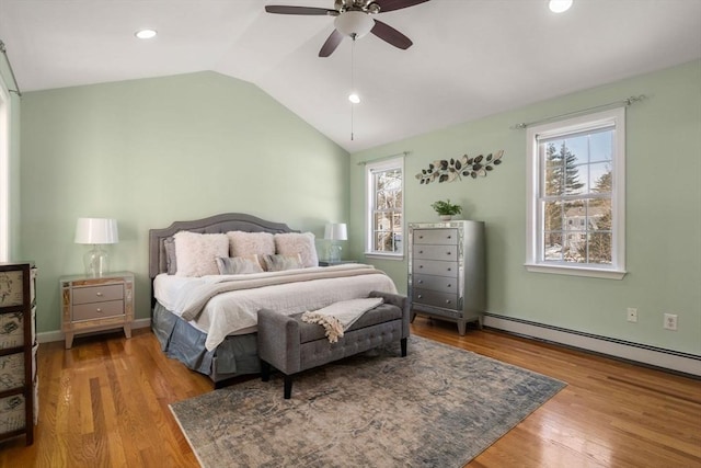 bedroom with a ceiling fan, lofted ceiling, wood finished floors, baseboard heating, and recessed lighting