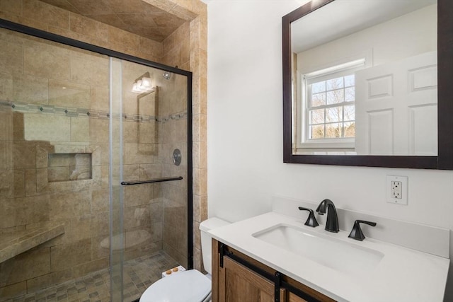 full bathroom featuring a shower stall, toilet, and vanity