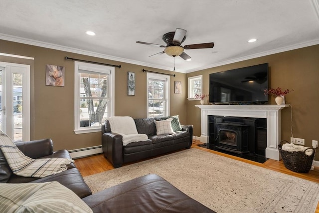 living area featuring ornamental molding, baseboard heating, baseboards, and light wood finished floors