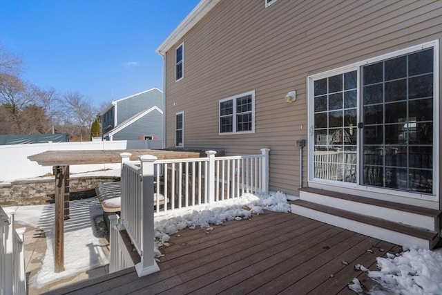 snow covered deck featuring fence