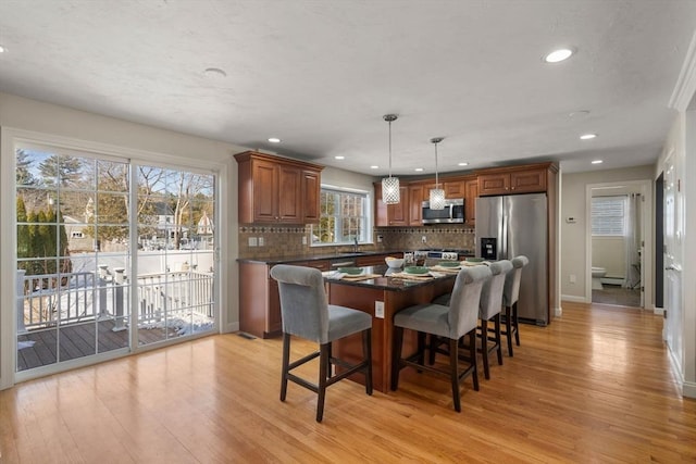 dining area with light wood-style flooring, baseboards, and recessed lighting