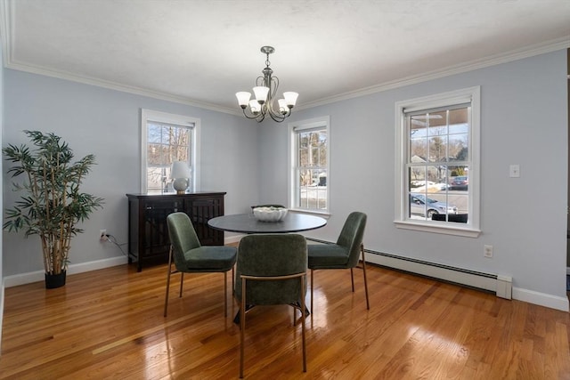 dining space with a notable chandelier, a baseboard heating unit, light wood-style floors, ornamental molding, and baseboards