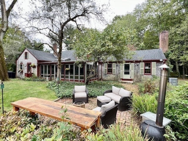 back of house with outdoor lounge area and a lawn