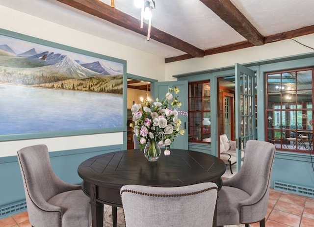 tiled dining area featuring beamed ceiling