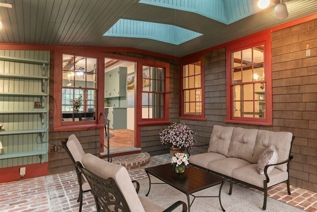 sunroom featuring lofted ceiling with skylight