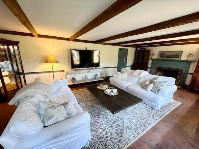 living room with beam ceiling and dark hardwood / wood-style flooring