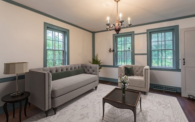 living room featuring an inviting chandelier, crown molding, and hardwood / wood-style floors