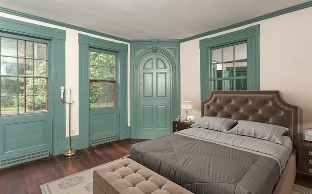 bedroom with ornamental molding and dark wood-type flooring