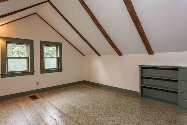 additional living space with vaulted ceiling with beams