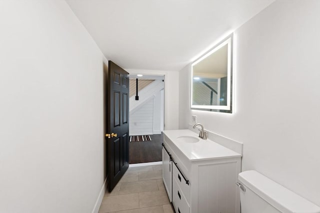 bathroom featuring toilet, tile patterned floors, and vanity