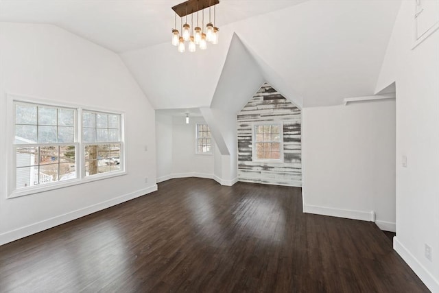 bonus room with dark hardwood / wood-style flooring, lofted ceiling, and a chandelier