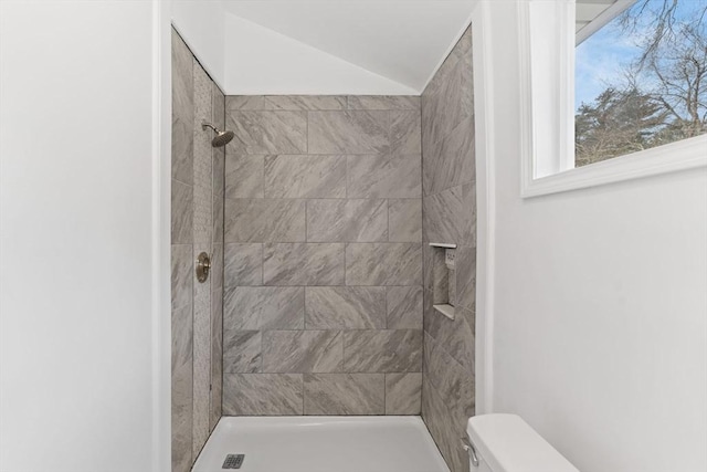 bathroom featuring toilet and a tile shower