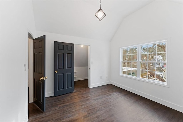 unfurnished bedroom with a walk in closet, vaulted ceiling, and dark hardwood / wood-style floors