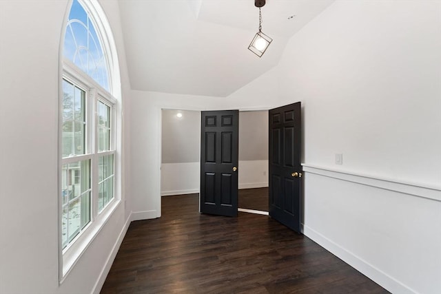 empty room with vaulted ceiling and dark hardwood / wood-style flooring