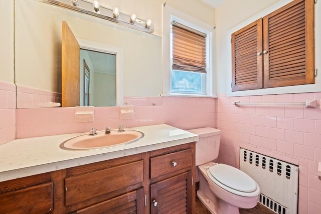 84 Tremont St, Taunton, MA 02780 - half bathroom with radiator, toilet, tile walls, vanity, and a wainscoted wall