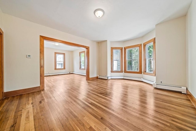 84 Tremont St, Taunton, MA 02780 - unfurnished living room featuring light wood-style floors, baseboards, baseboard heating, and a baseboard radiator