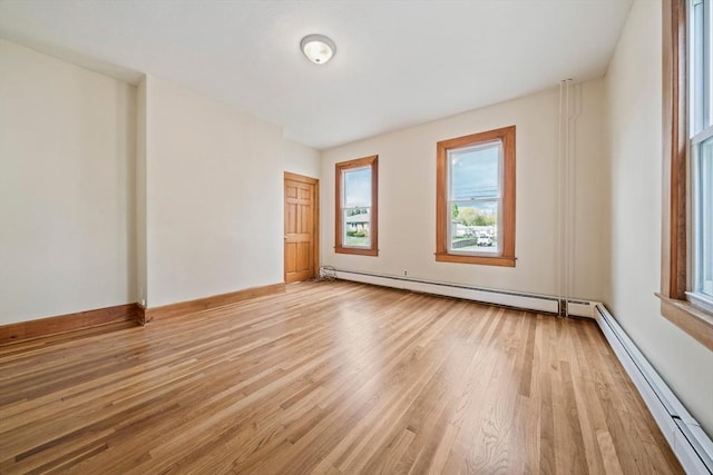 84 Tremont St, Taunton, MA 02780 - empty room featuring baseboard heating, light wood-style flooring, baseboards, and a baseboard radiator