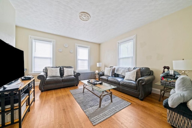 84 Tremont St, Taunton, MA 02780 - living area featuring a textured ceiling, light wood-style floors, radiator, and baseboards
