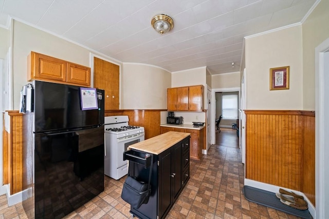 84 Tremont St, Taunton, MA 02780 - kitchen featuring freestanding refrigerator, white range with gas cooktop, ornamental molding, a wainscoted wall, and wood walls