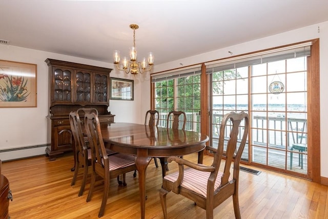 dining room with baseboard heating, light hardwood / wood-style flooring, and a notable chandelier