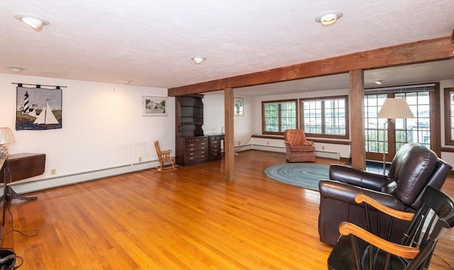 living room with a baseboard radiator, a textured ceiling, and light wood-type flooring