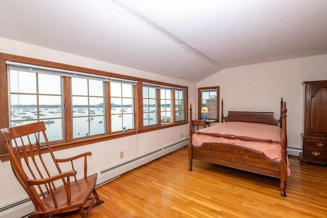 bedroom featuring light wood-type flooring, a water view, baseboard heating, and lofted ceiling