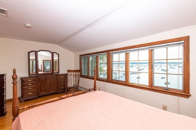 bedroom with light hardwood / wood-style floors and vaulted ceiling