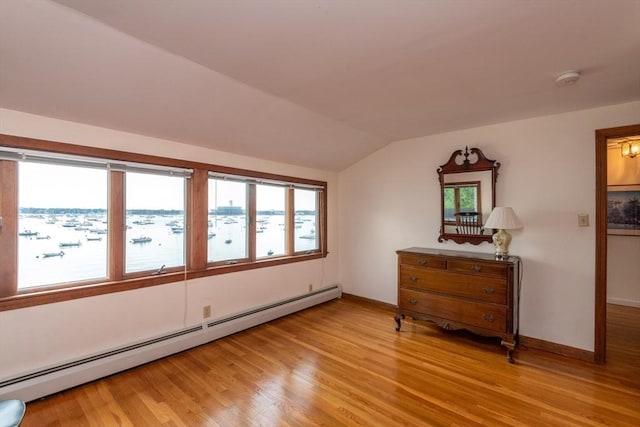 interior space with light hardwood / wood-style flooring, a baseboard heating unit, and lofted ceiling