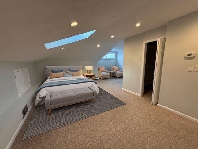 carpeted bedroom with baseboards, lofted ceiling with skylight, visible vents, and recessed lighting