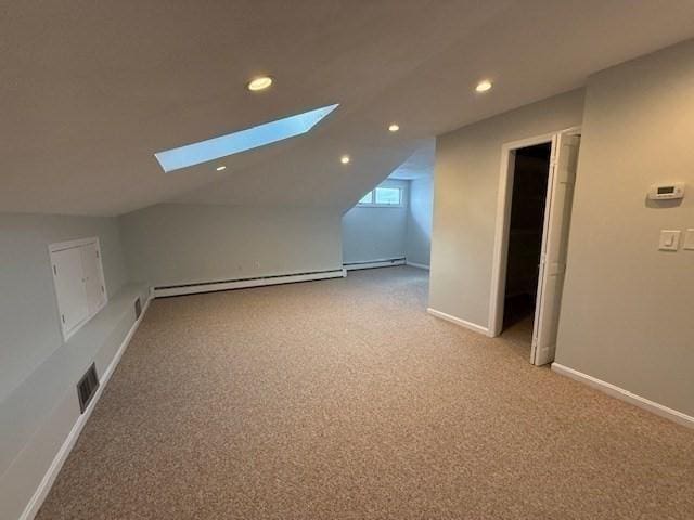 bonus room featuring a baseboard radiator, light colored carpet, visible vents, baseboard heating, and lofted ceiling with skylight