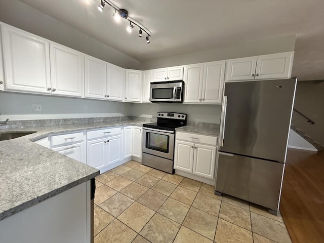 kitchen featuring light tile patterned floors, white cabinets, stainless steel appliances, light countertops, and a sink