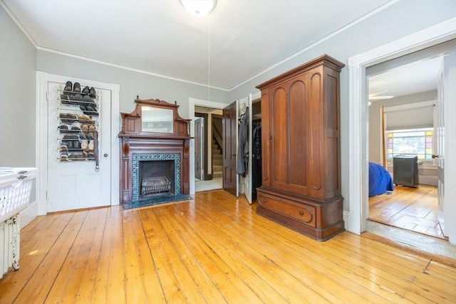 14 Baker St, Foxboro, MA 02035 - unfurnished living room with light wood-style floors, a tile fireplace, ornamental molding, stairs, and a ceiling fan