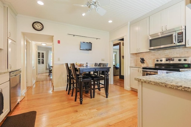 14 Baker St, Foxboro, MA 02035 - kitchen featuring stainless steel appliances, light wood-type flooring, tasteful backsplash, white cabinets, and ornamental molding