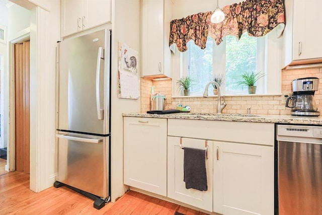 14 Baker St, Foxboro, MA 02035 - kitchen featuring appliances with stainless steel finishes, light wood-style flooring, white cabinets, decorative backsplash, and light stone counters