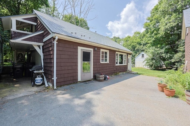 14 Baker St, Foxboro, MA 02035 - view of property exterior featuring asphalt driveway, a patio area, a shingled roof, and a garage