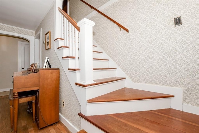 54 Converse Rd, Marion, MA 02738 - staircase featuring wood-type flooring, wallpapered walls, and arched walkways