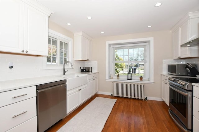 54 Converse Rd, Marion, MA 02738 - kitchen featuring radiator, appliances with stainless steel finishes, white cabinetry, backsplash, and light countertops