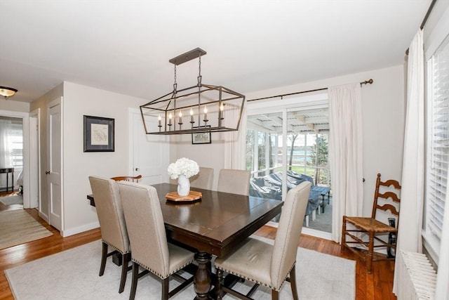 54 Converse Rd, Marion, MA 02738 - dining room with radiator, wood finished floors, baseboards, and a chandelier