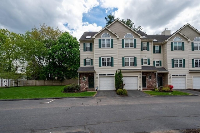 multi unit property with driveway, an attached garage, and brick siding