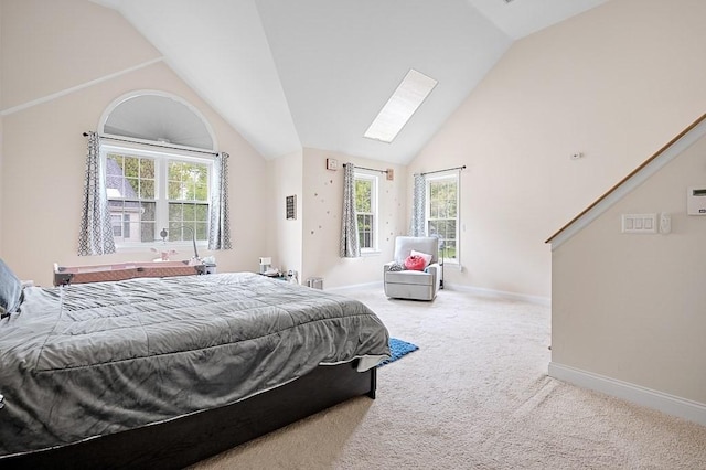 bedroom featuring lofted ceiling, carpet flooring, baseboards, and a skylight